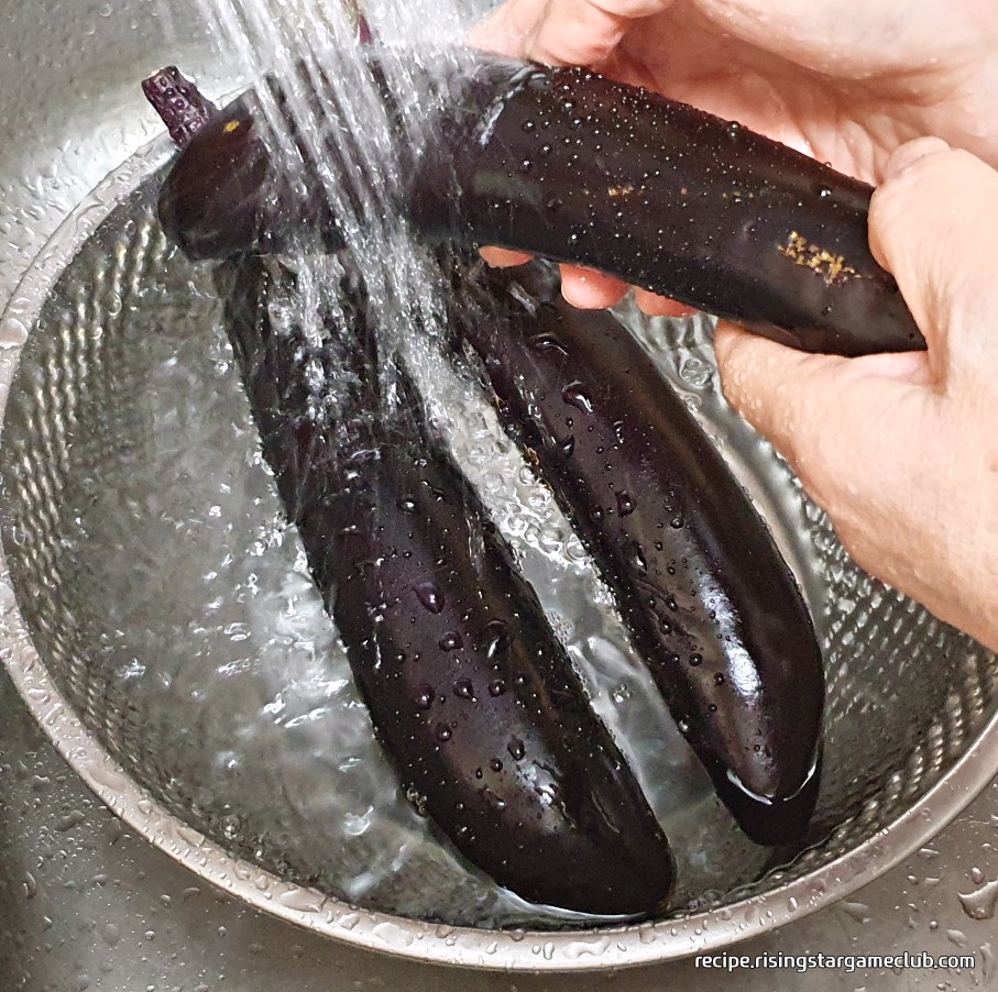 가지 무침을 하기위해 가지 3개를 흐르는 물에 깨끗하게 씻어 주는 사진