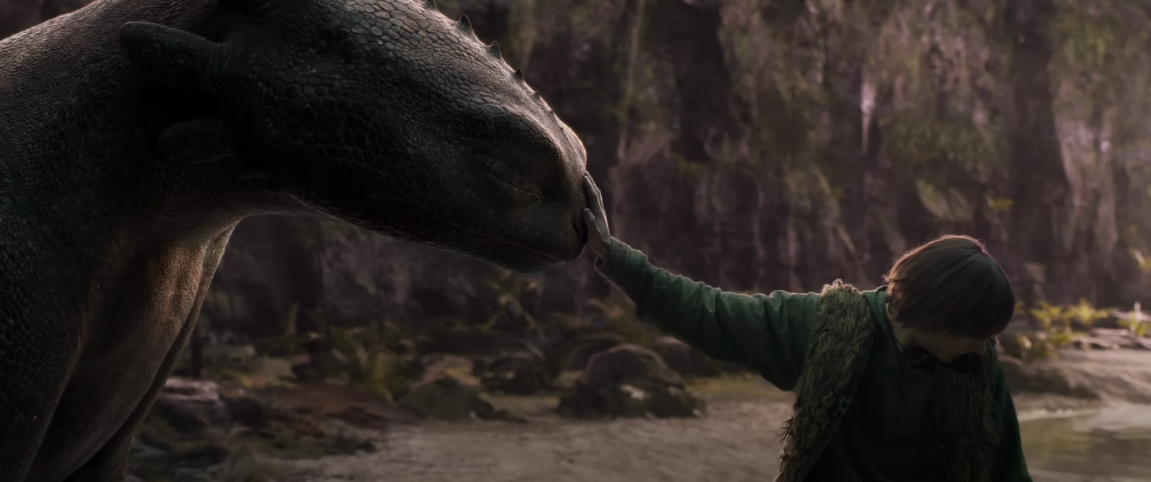 드래곤의 코에 소년이 손을 얹고 있다.