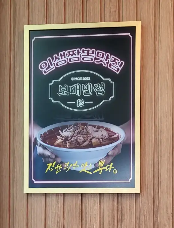 보배반점 - 나무벽면 액자안 인생짬뽕맛집 이라고 적힌 액자