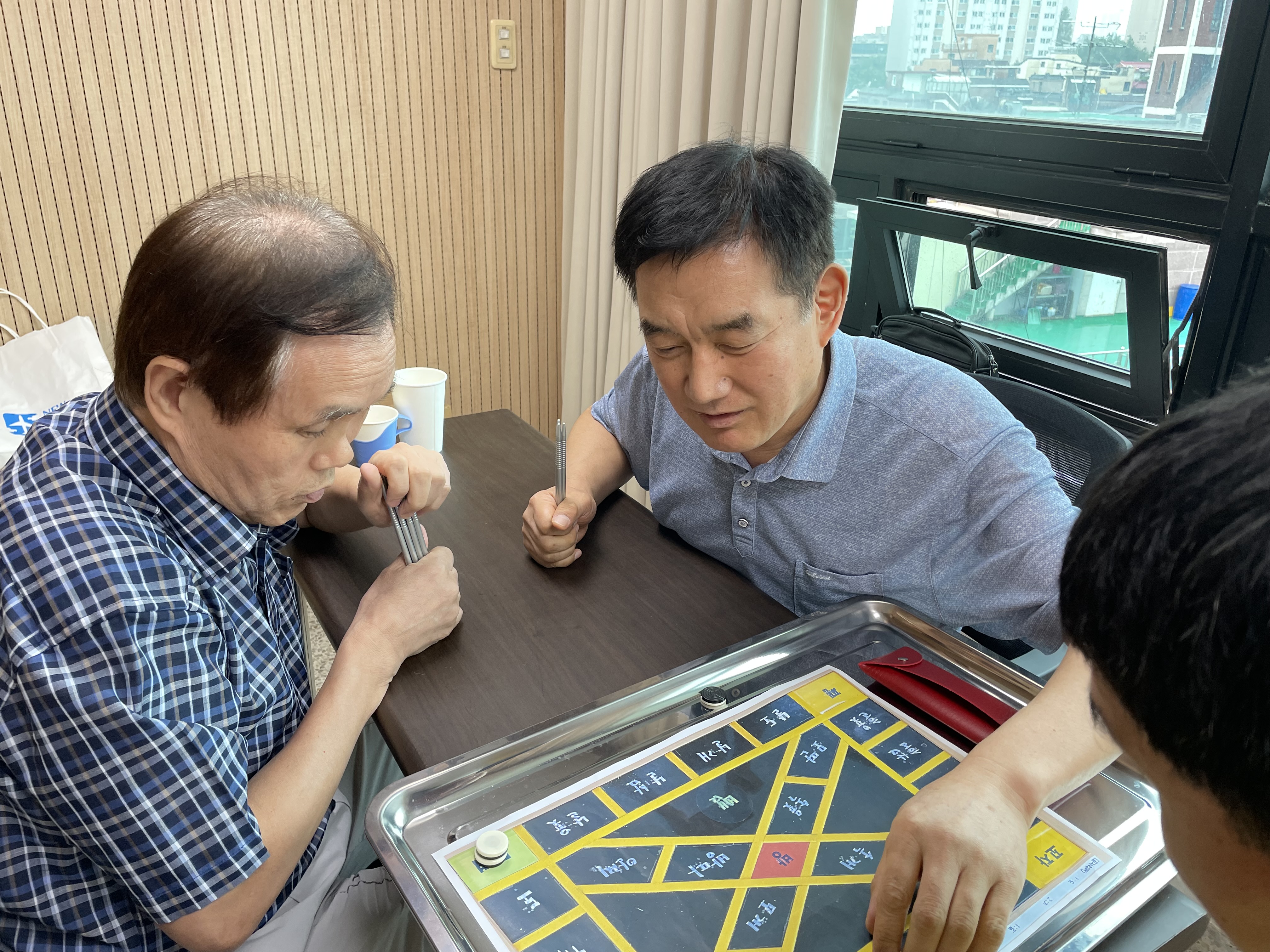 이미지 설명: 1부 윷놀이 경기사진. 부전승으로 올라간 김종산 지회원과 김종창 지회원이 경기중임.