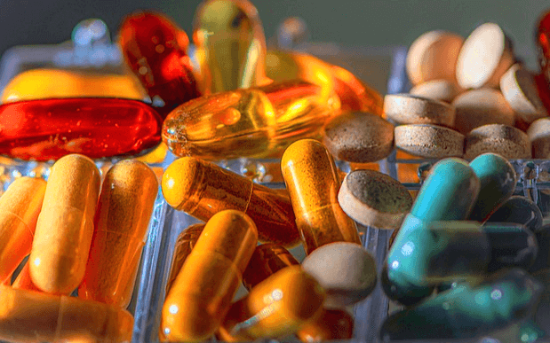 타원형의 알약들이 한가득 있다. 노란색, 하늘색, 불은색 약들이다.