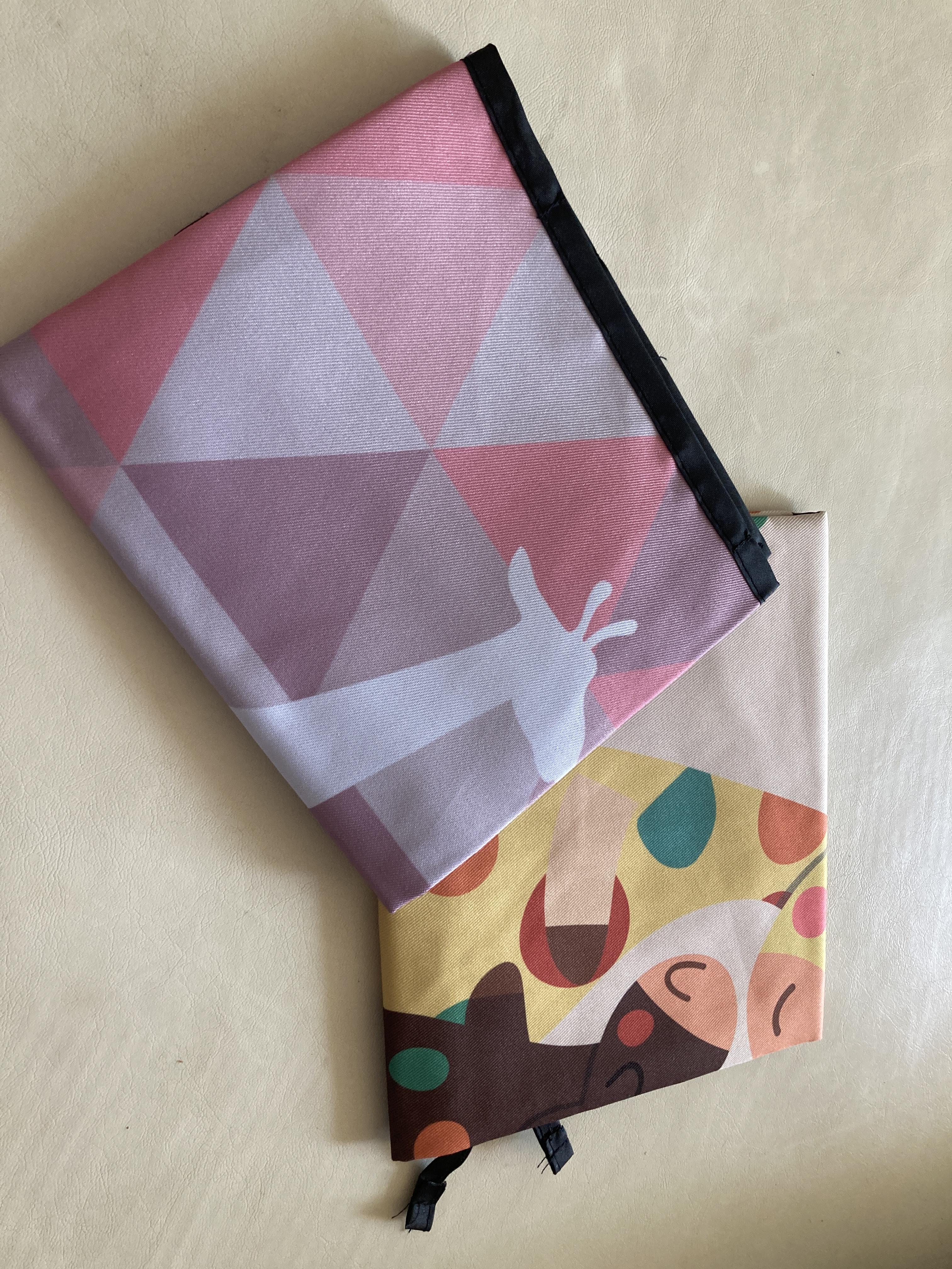 지프라기와 패턴이 그려진 접힌 자석식 햇빛가리개 두 개, 알록달록한 디자인