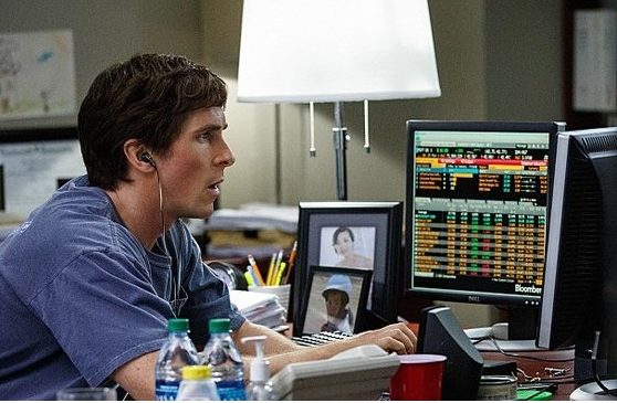 영화 속 주인공이 컴퓨터로 주식 차트를 보는 모습