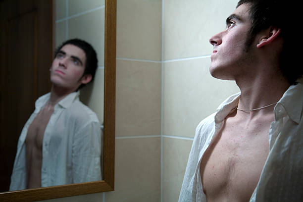 우울한 표정으로 거울을 바라보는 모습