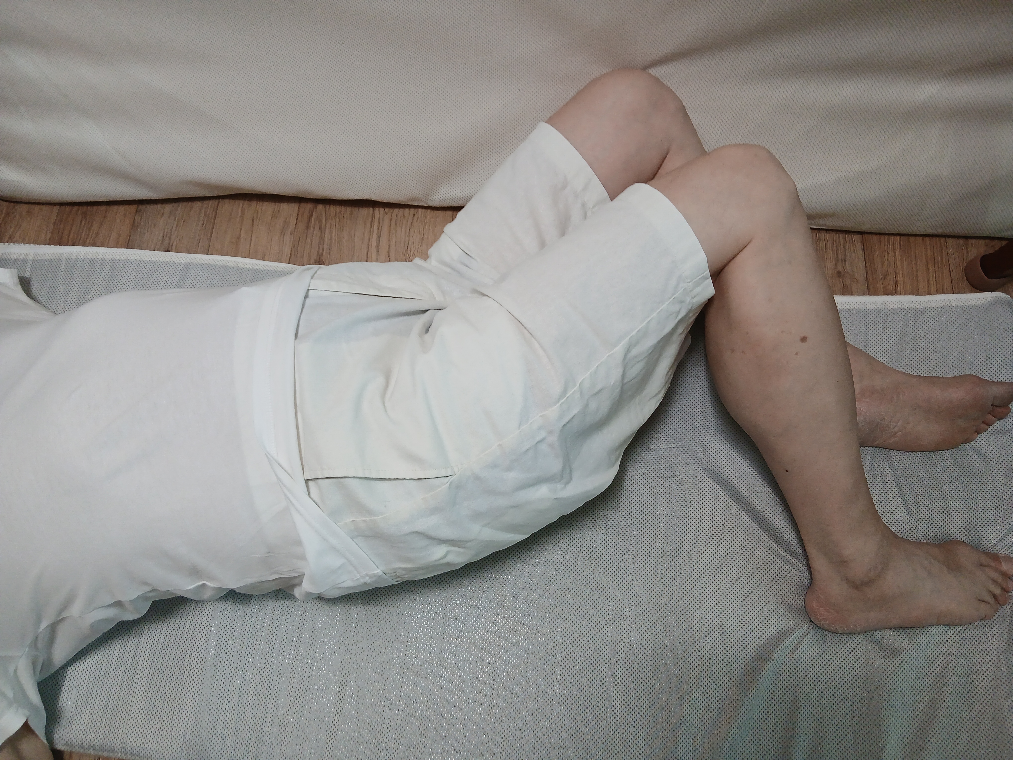 척추 주변 근육을 부드럽게 풀어주는 효과가 있는, 누운 상태에서 양팔을 옆으로 벌리고, 무릎을 굽혀 한쪽 방향으로 천천히 넘기는 동작 이미지