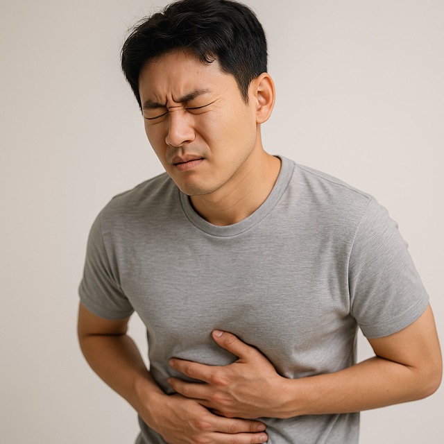 복통을 호소하며 배를 감싸쥔 채 고통스러운 표정을 짓고 있는 젊은 남성(출처: 자체제작)