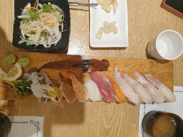 긴 나무 그릇에 12개의 스시가 놓여 있다. 길게 놓인 장어 스시에 눈길이 간다.