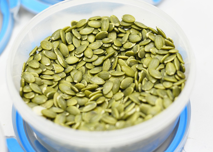 초록색 호박씨가 밀폐용기에 담겨있다