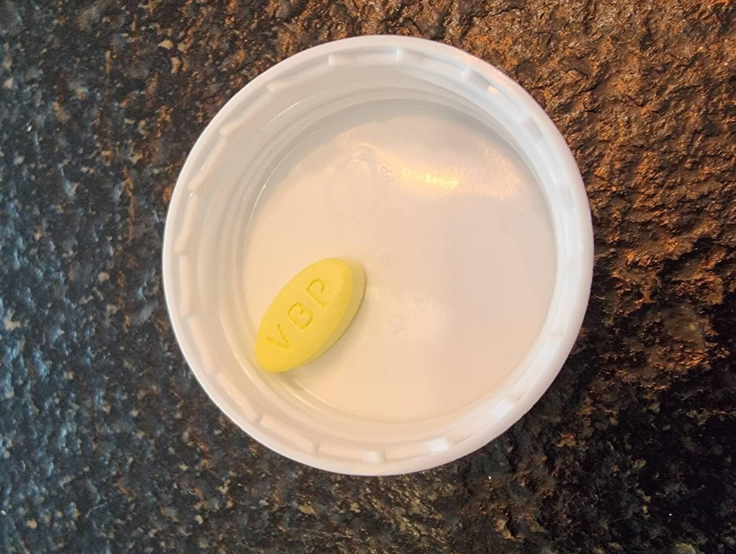 임팩타민 1정을 뚜껑 안에 넣어서 살펴봄