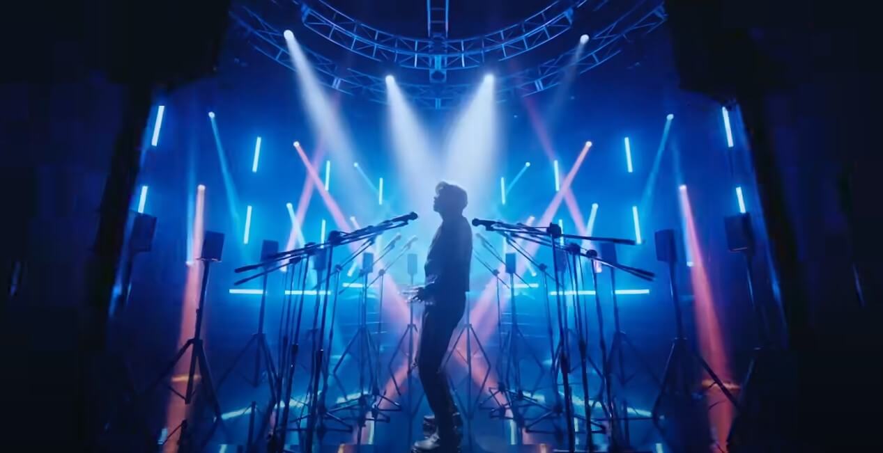 마이크에-둘러쌓여-빛을-받고있는-가수