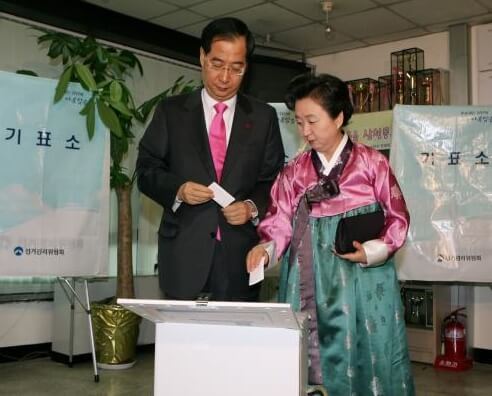 부부가 같이 투표소에서 투표중인 모습