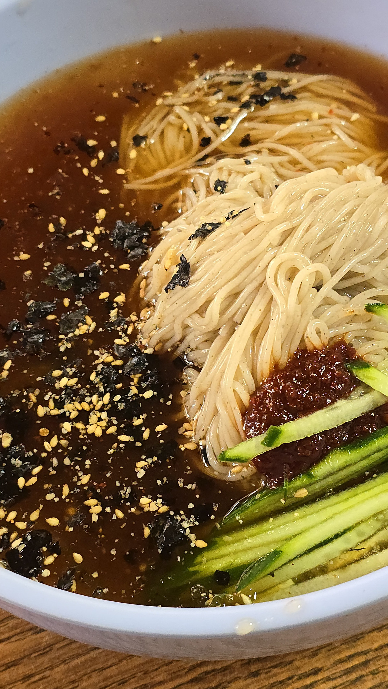 충남 부여 장원막국수의 국수 위에 김가루와 육수가 함께 어우러진 비주얼을 보여주는 음식 사진