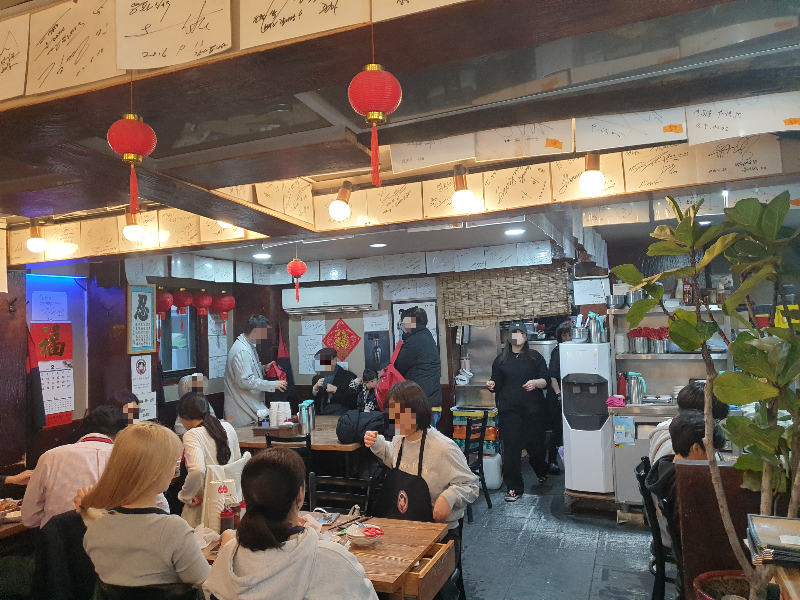 천장에는 홍등이 벽에는 붉은색 글자 장식이 붙어있다. 보 사이에는 유명인들의 사인이 부착되어 있다.