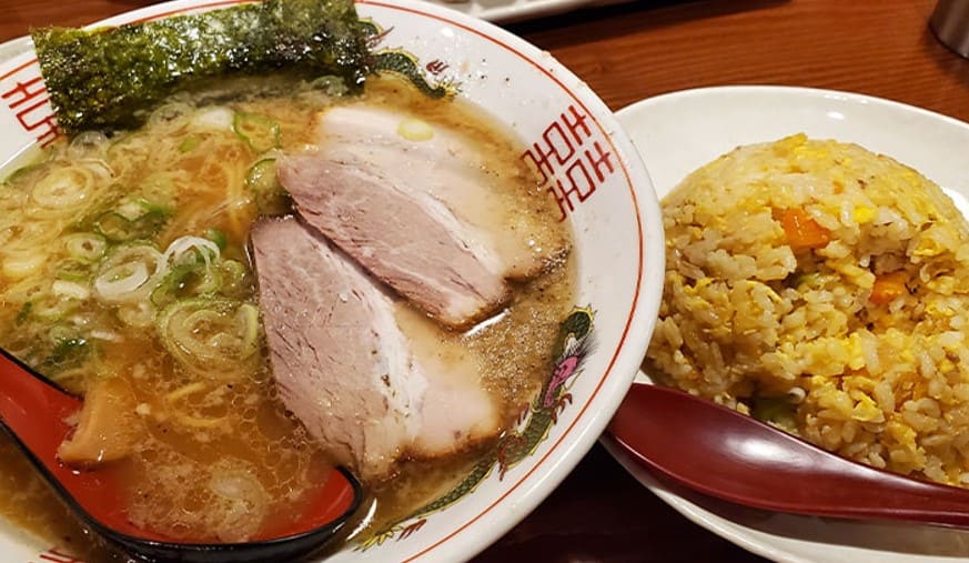 라면과 볶음밥이 테이블위에 올려져 있다 라면에는 차유와 대파 그리고 김이 올라가 있다