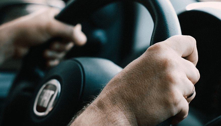 자동차 핸들을 잡고 있는 남성의 손