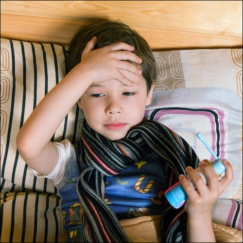 머리에 손을 얹어 열을 확인하는 소년