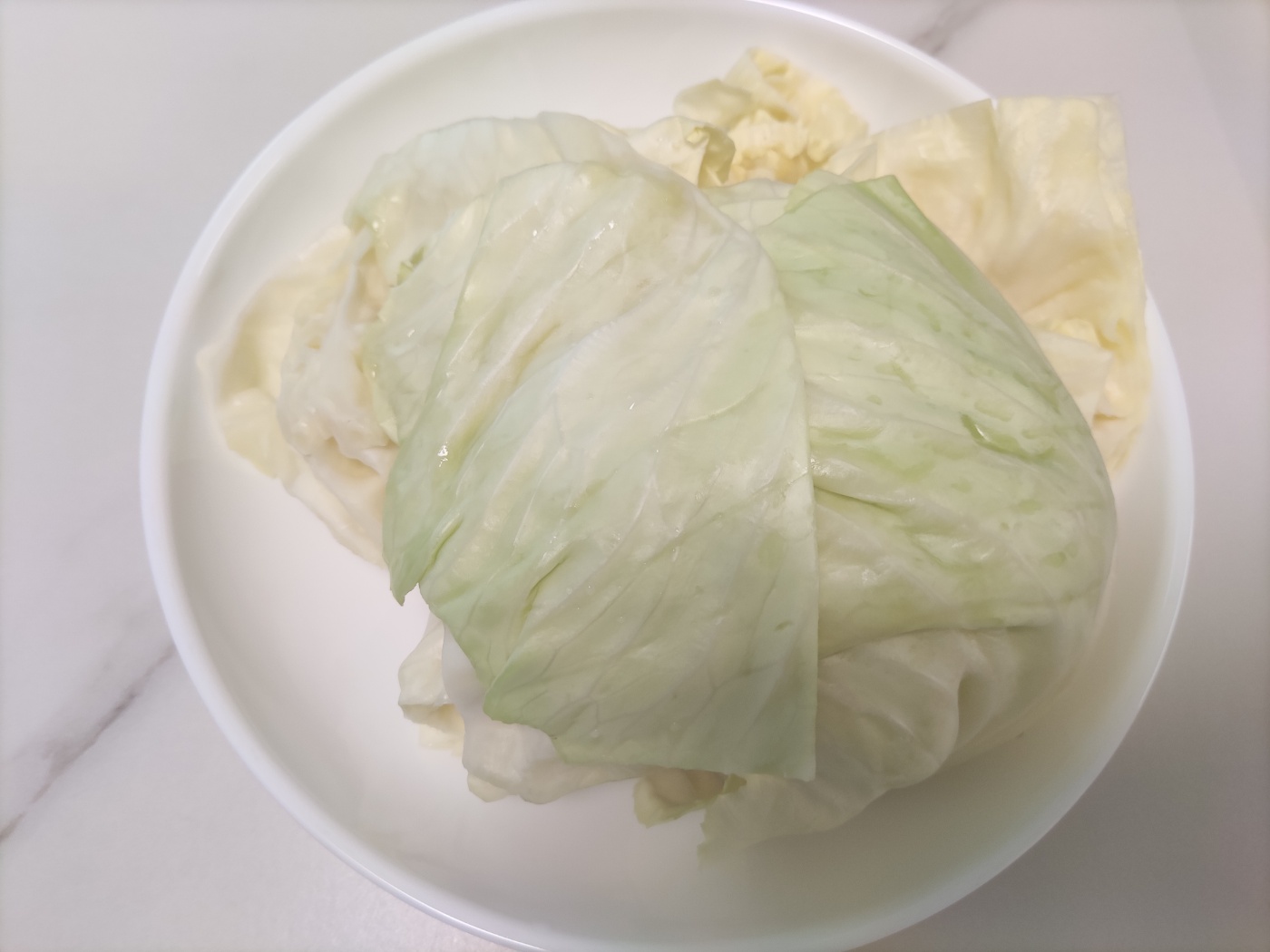 접시에 담긴 데친 양배추쌈. 내장지방 감소를 위한 효과적인 양배추 섭취 방법