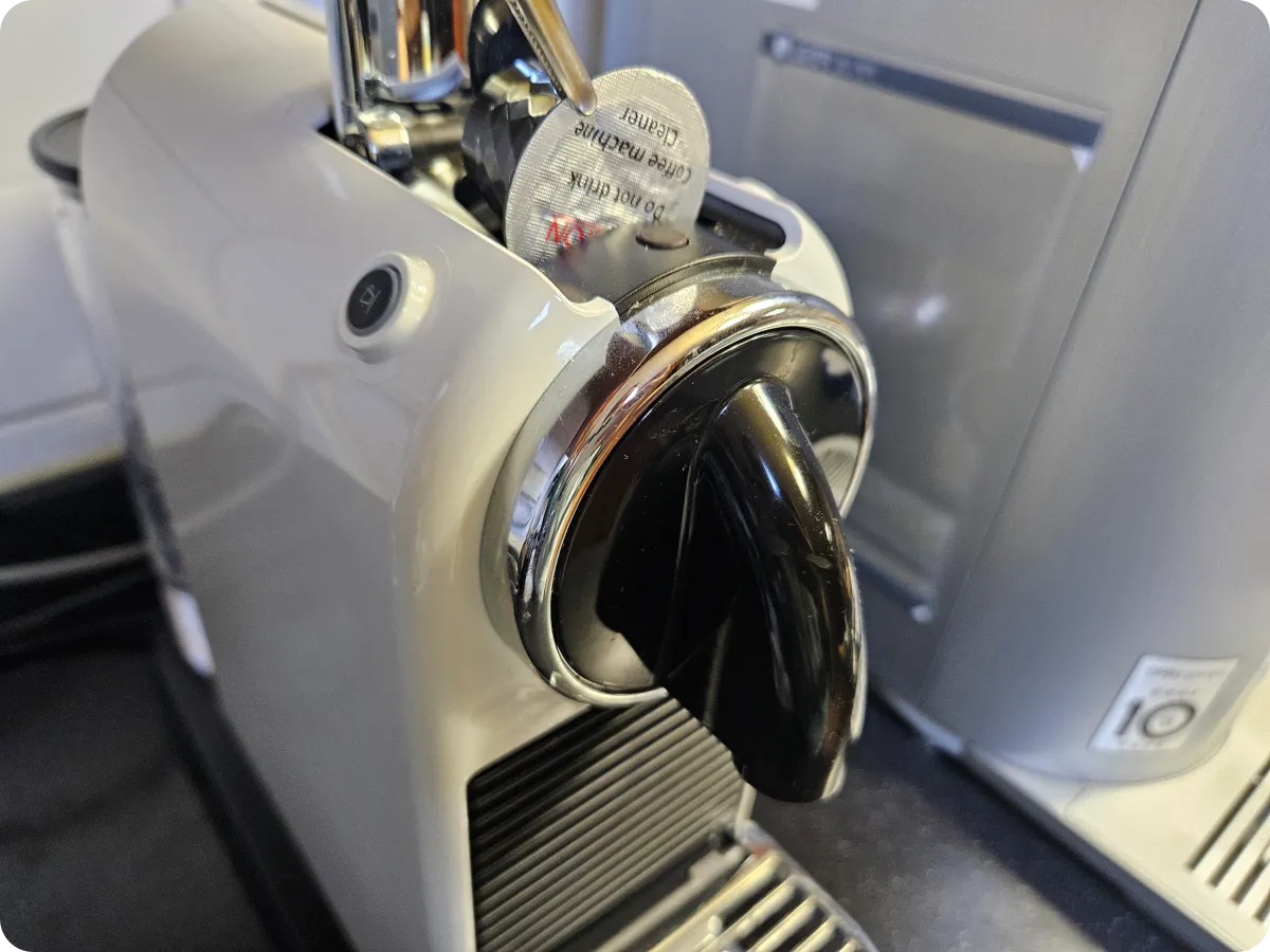 네스프레소-커피-캡슐-머신에-집게로-세척-캡슐을-넣기