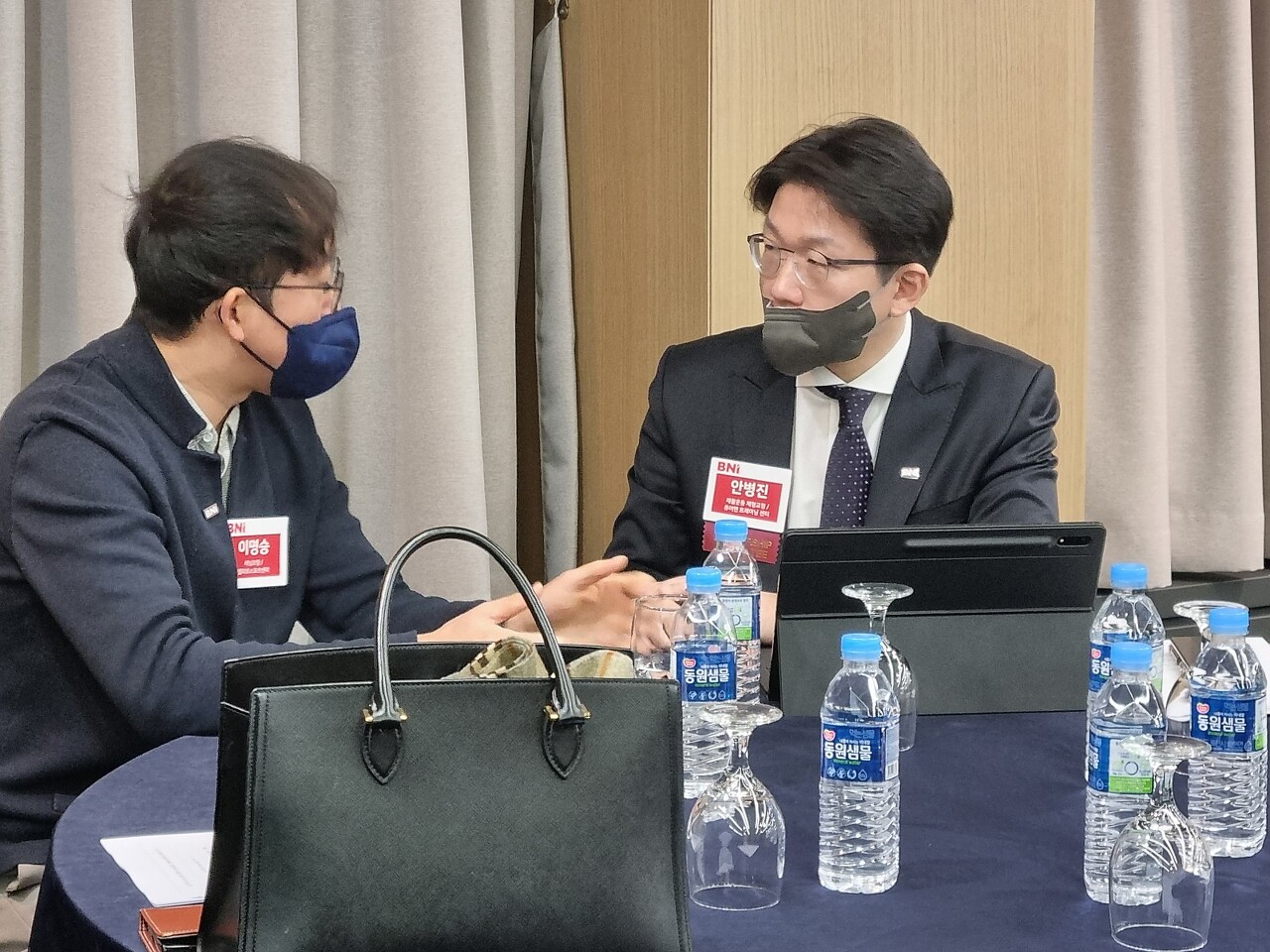 BNI 헬스케어 파워팀 러닝코치 이명승 대표님과 리픽스 재활의 안병진 대표님이 회의실에 앉아 담소를 나누고 있습니다.