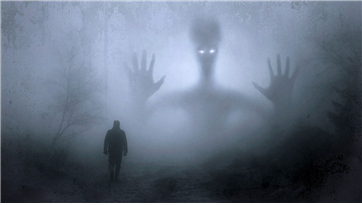 어둡고 안개 자욱한 산길 멀리서 보이는 거인인지 괴물인지 분간이 어려운 그림자와 그 괴물에게로 걸어가는 사람 뒷모습 사진