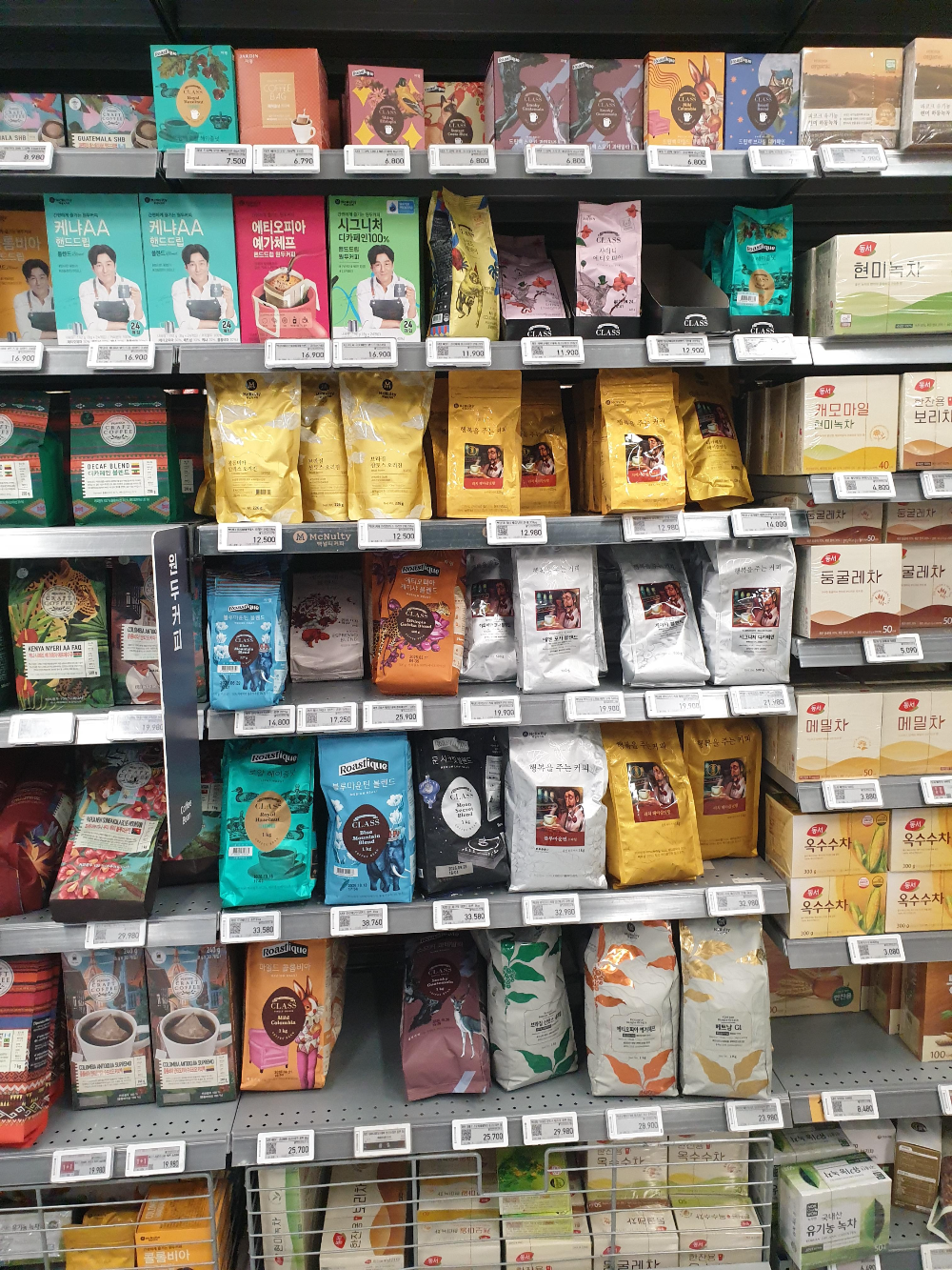 마트 진열대에 다양한 원두들이 놓여 있다.