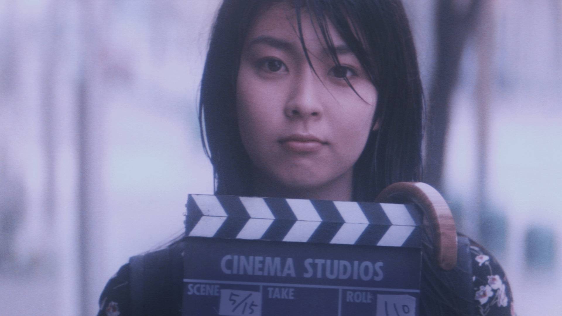 영화 촬영용 클랩보드를 들고 정면을 바라보는 여주인공 우즈키의 모습, 영화 4월 이야기 스틸컷