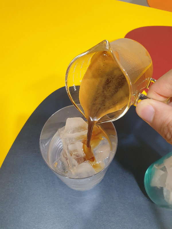 얼음물이 담긴 유리컵에 에스프레소를 붓는 중