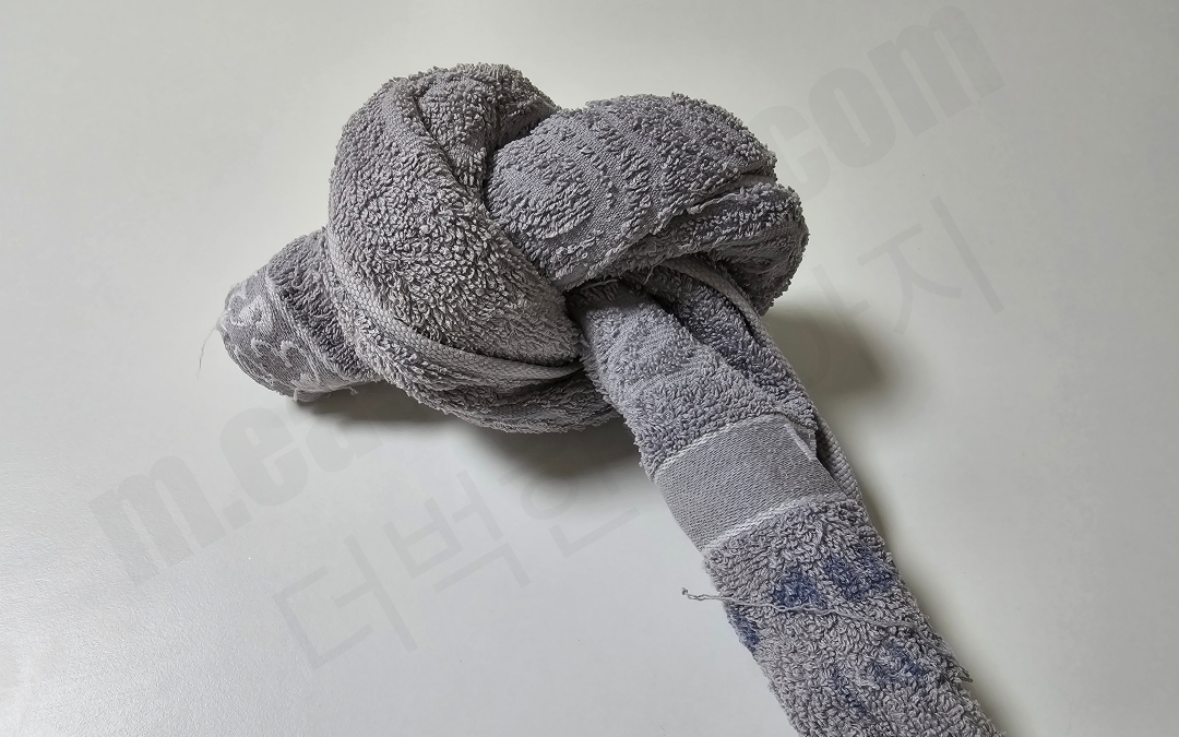 수건을 돌돌 말아 한 번 묶은 모습