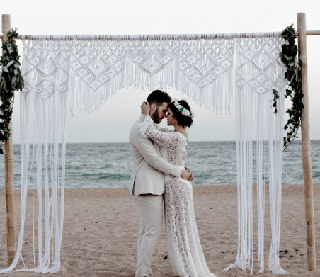 아름다운 바닷가에서 서로 얼굴을 맞대고 있는 신랑과 신부 사진