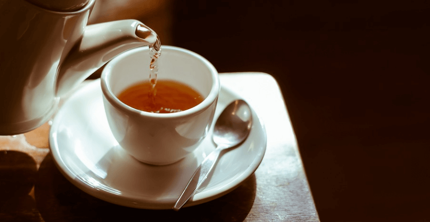 찻잔에 주전자로 차를 따르고 있는 모습