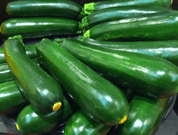 기다랗고 초록색인 애호박들이 한가득 쌓여있다. 겉은 단단하고 매끄럽다.
