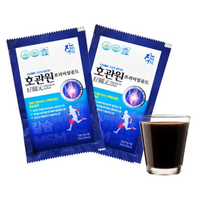 호관원 프리미엄 골드 두 포와 컵에 담긴 액상 호관원 사진