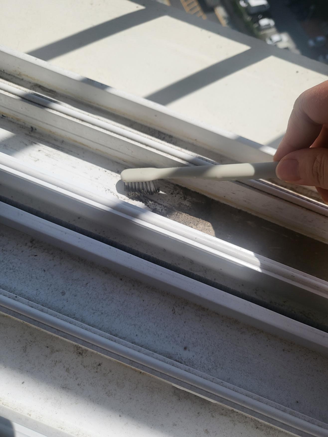 칫솔로 창틀에 가라앉은 먼지를 가운데로 긁어모으는 장면