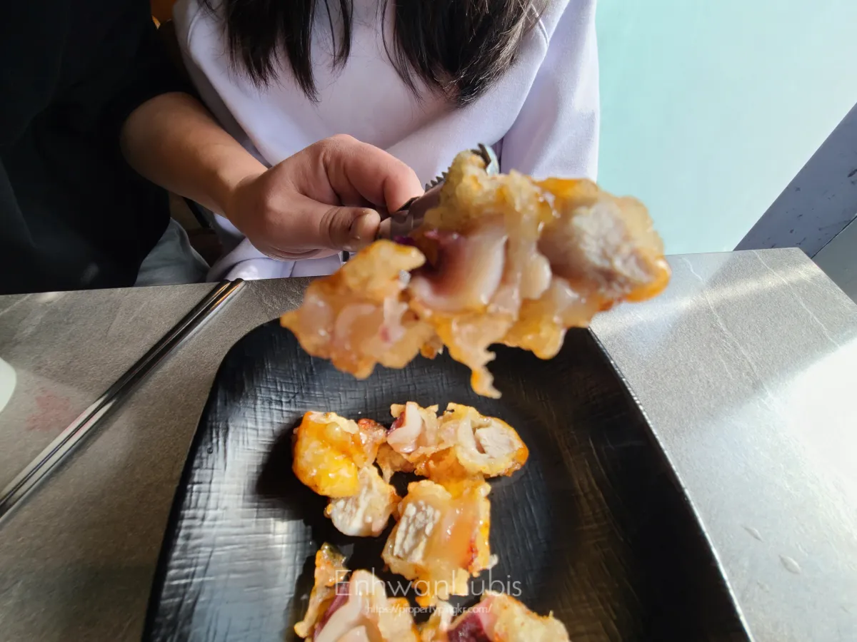 거동탕수육-반으로-자른-것을-집게로-들고있는-고기반-문어반