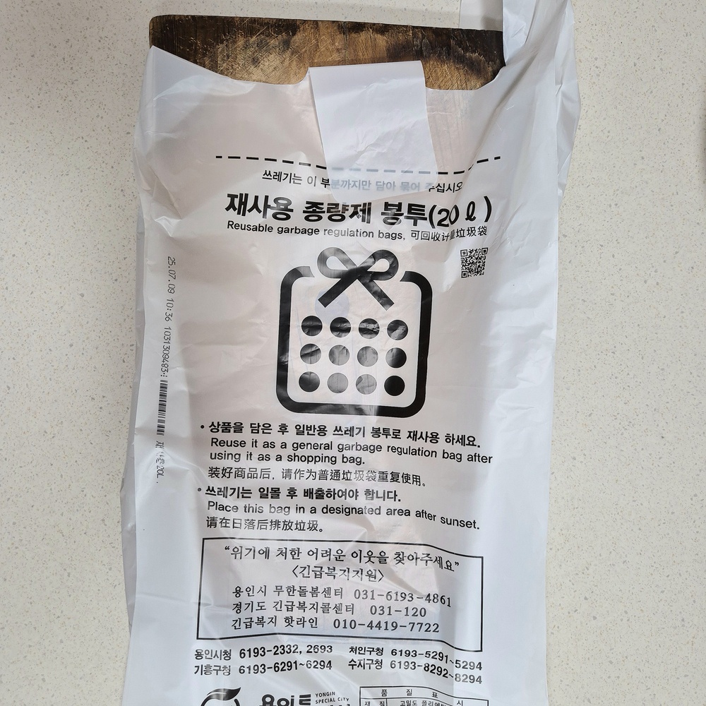 나무 도마가 종량제봉투에 들어가는지 크기를 확인하는 모습
