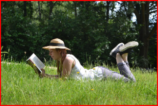 잔디밭에 누워 책을 읽으며 자연의 평온을 느끼는 모습