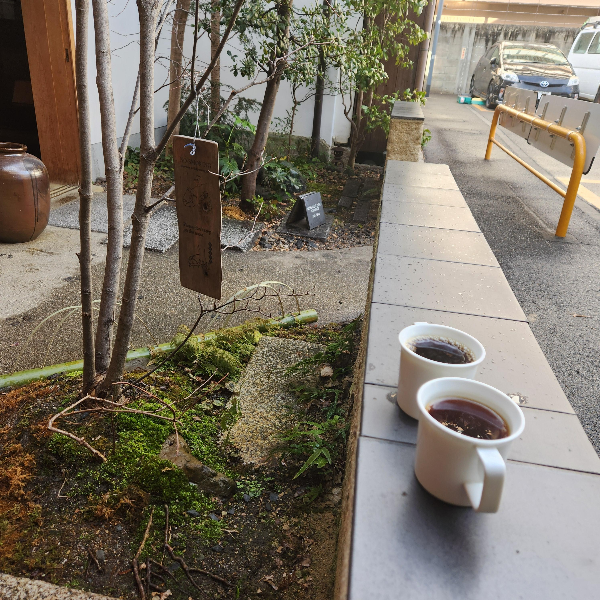 야외 좌석 옆 낮은 담에 커피를 놓고 한 컷.