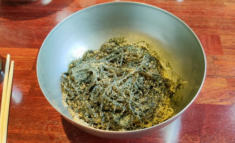 들기름 막국수 메밀면에 깨소금 김가루 들기름이 뿌려져있다.