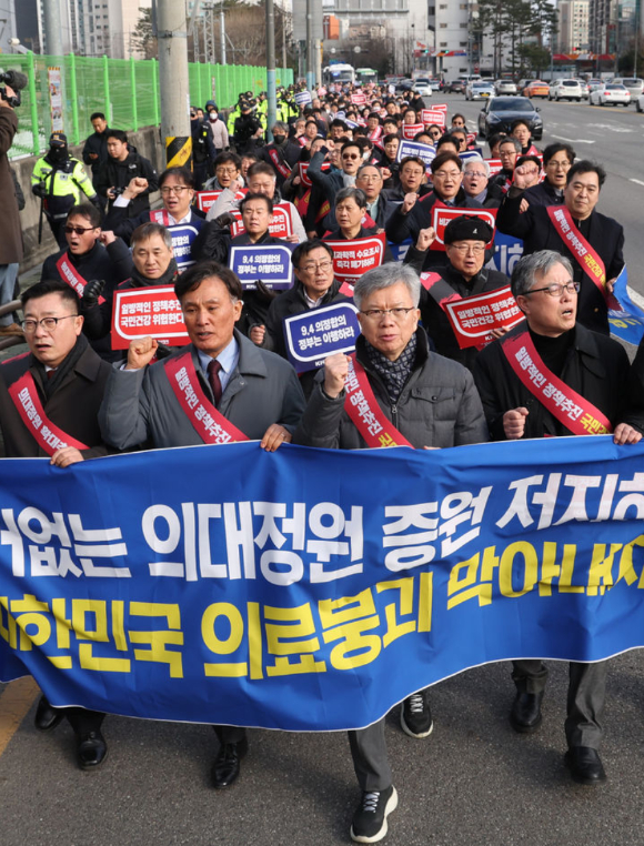 김택우 대한의사협회 비상대책위원장과 의사 대표자들이 지난 25일 서울 대한의사협회에서 열린 '의대 정원 증원 저지를 위한 전국 의사 대표자 확대회의'를 마친 후 대통령실을 향해 행진을 하고 있다. [사진=뉴시스]