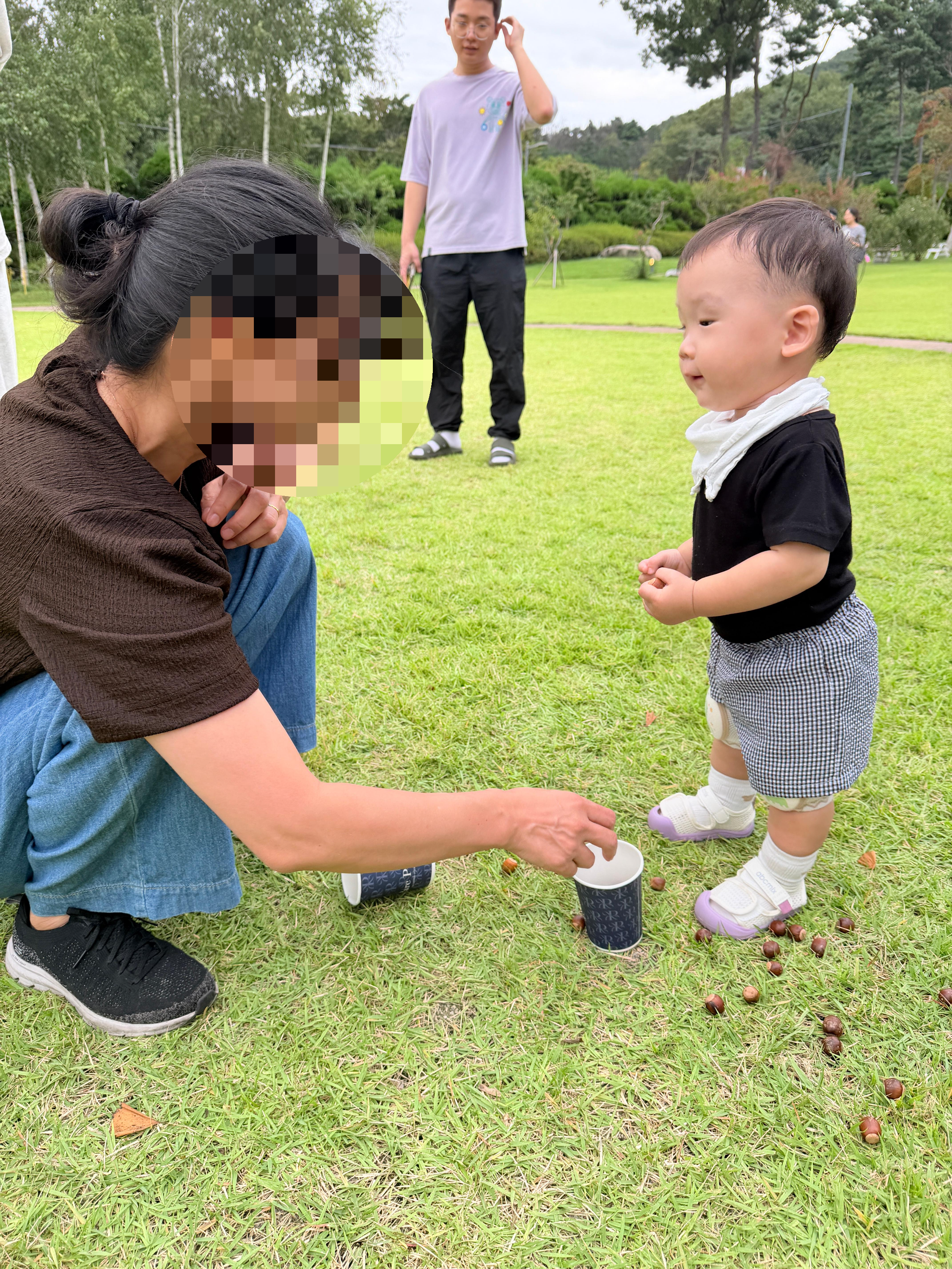 파크프리베 잔디밭에서 도토리를 나눠주는 낯선 사람을 보고 있는 아기 솔블리