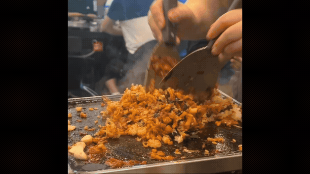 솔밭식당 이모님이 불판 위에서 고기 기름으로 볶음밥을 지글지글 볶는 모습, 김가루와 고기기름이 어우러져 맛있는 향이 퍼지는 장면