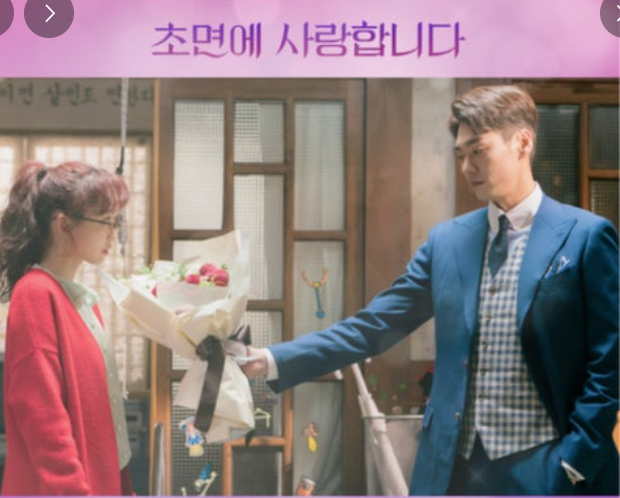 갈희집에 찾아온 민익이 빨간 가디건을 입은 갈희에게 꽃다발을 건넨다.