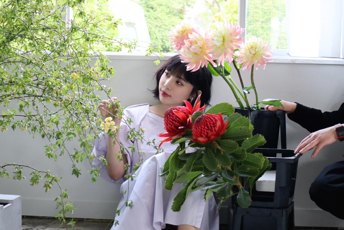 꽃 사이에 앉은 야스이 카오루