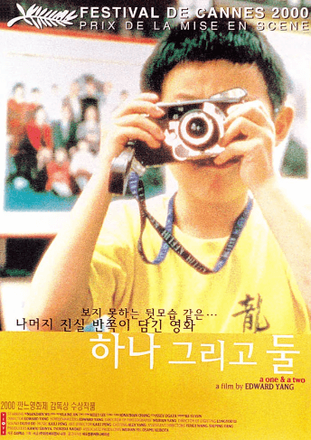 하나 그리고 둘 영화의 메인 포스터 소년이 사진기로 사진을 찍고 있다. 소년은 노란색 반팔 티셔츠를 입고 있다.