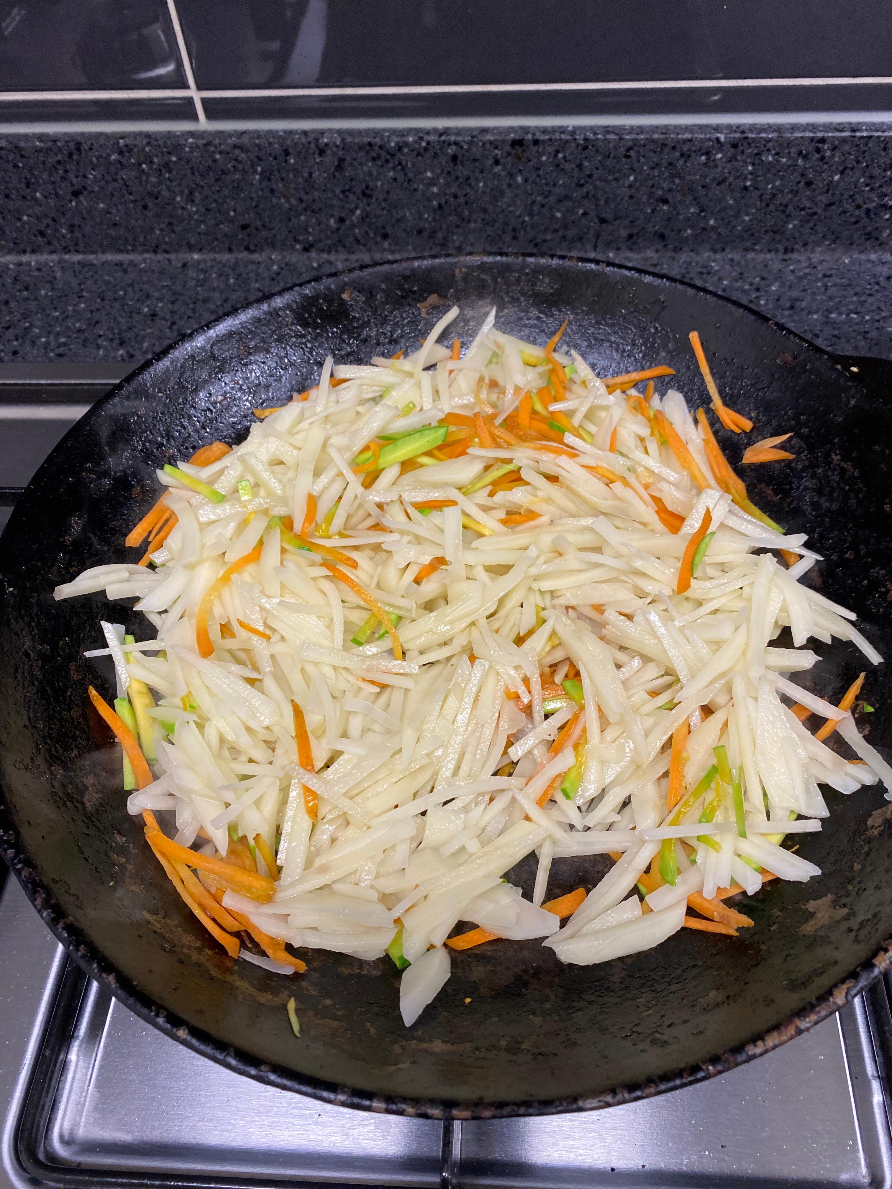 볶고있는 당근과 애호박에 채썬 감자 올려서 섞기