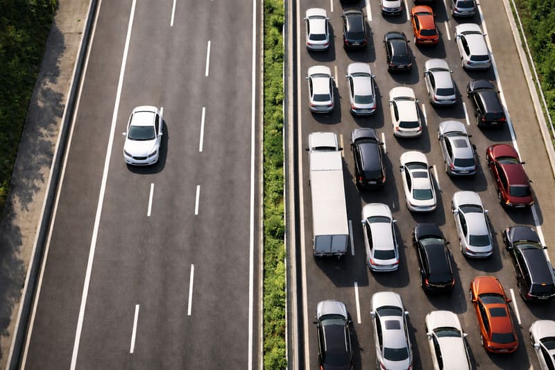 차로가 나뉜 고속도로와 도심 도로, 횡단보도가 함께 보이는 교통 환경 전경