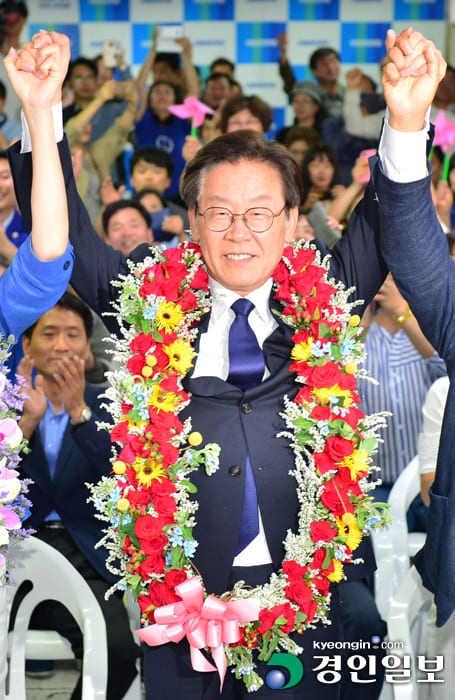 경기도지사에 당선되어 꽃목걸이를 한 채 두팔을 든 이재명
