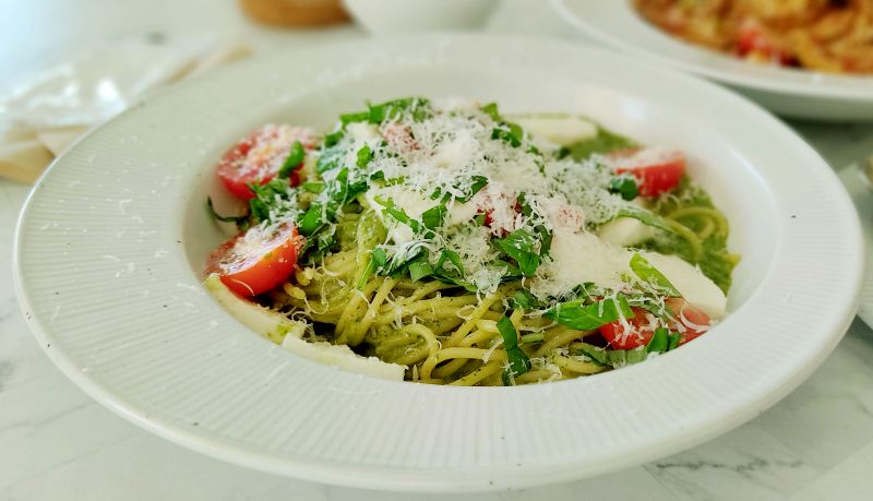 초록 바질페스토 하얀 생모짜렐라 빨간 방울토마토가 그림같이 플래이팅 되어있는 제도베제 파스타