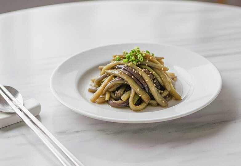 증기에 쪄낸 후 손으로 결대로 찢어 양념장에 조물조물 버무린 촉촉한 가지무침