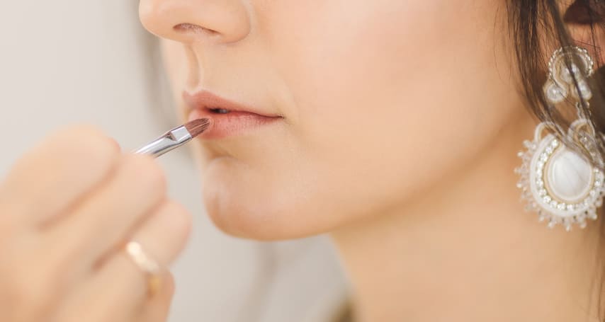 입술에 립스틱을 바르고 있는 여자